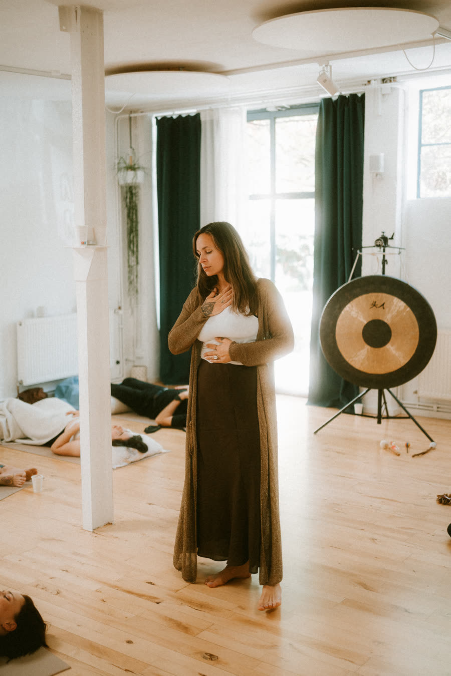 Nic standing with a hand on the heart while a room breathes