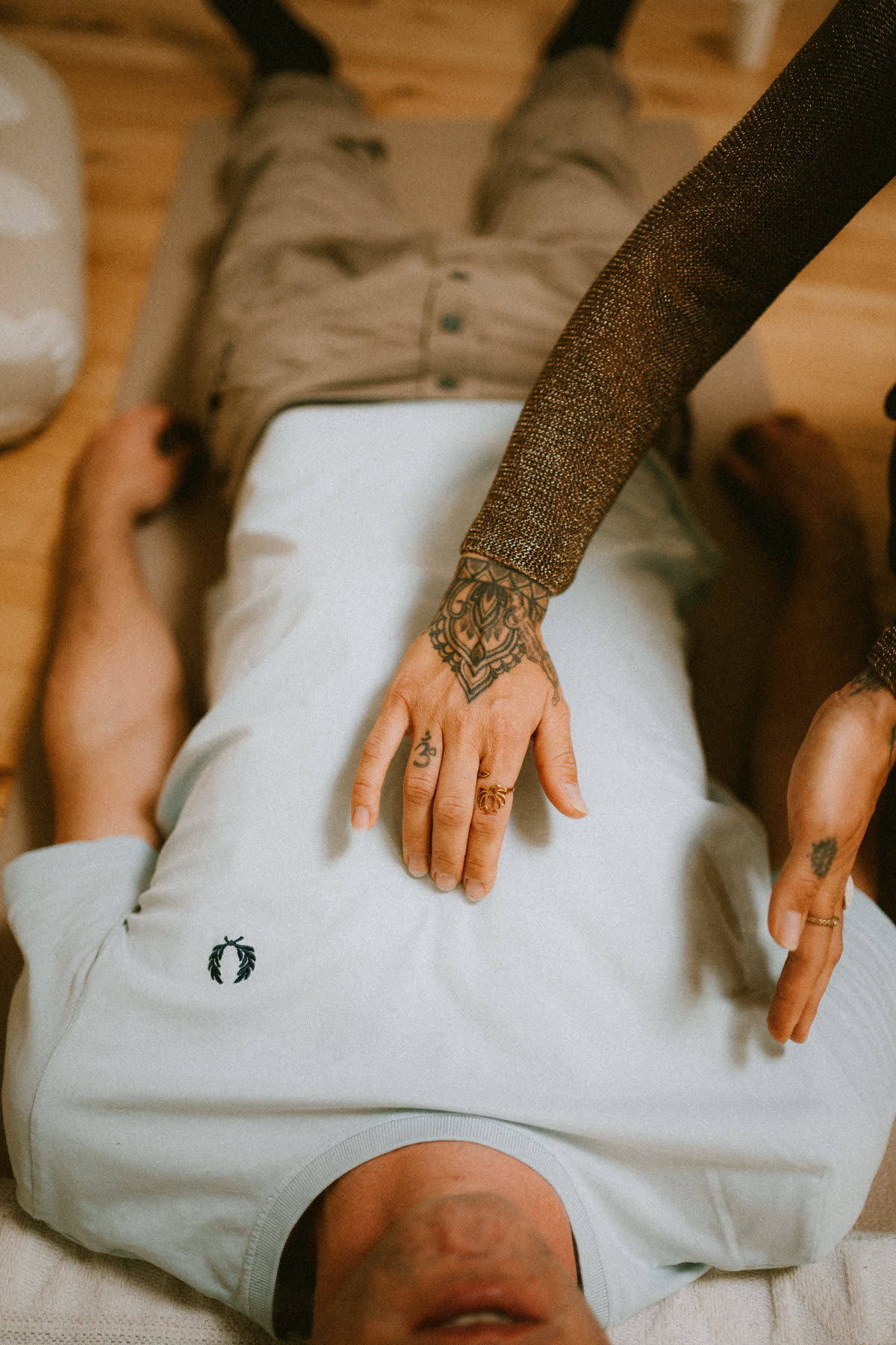 A facilitator's hands giving grounding touch during a session